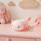 Veilleuse bébé axolotl rose sur une commode de chambre bébé
