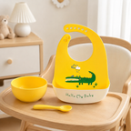 Bavoir bébé en silicone jaune motif crocodile sur une chaise haute