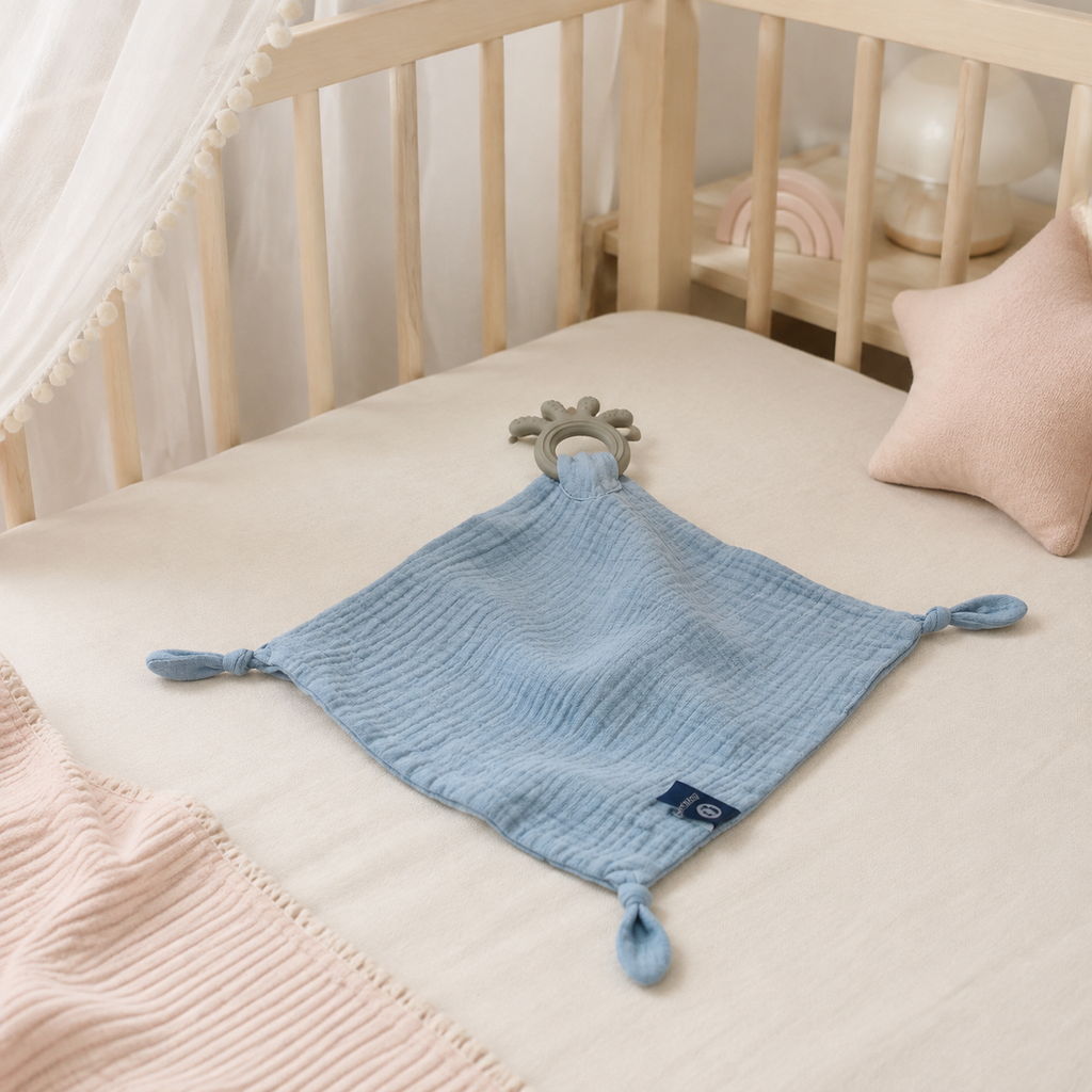 Doudou-lange bébé bleu en mousseline dans un lit bébé