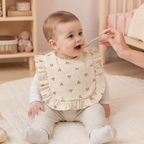 Bébé portant un bavoir à volants motif cœurs