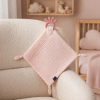 Doudou-lange bébé rose sur un fauteuil d’allaitement