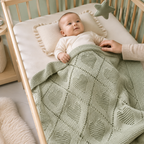 Bébé éveillé sous une couverture en maille vert sauge