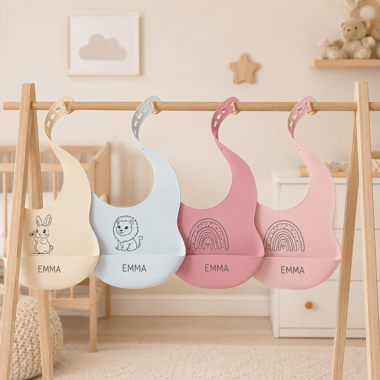 Quatre bavoirs bébé personnalisés présentés sur un portant en bois