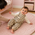 Bébé portant la salopette beige à motif noir dans sa chambre