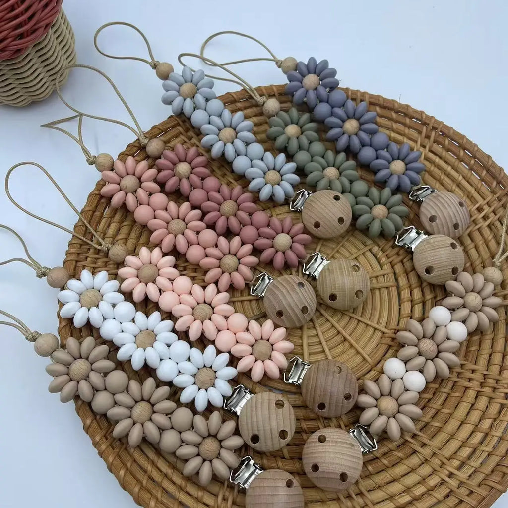 Attache Tétine Petite Fleur Marguerite, un accessoire pratique et stylé pour garder la tétine de bébé à portée de main.