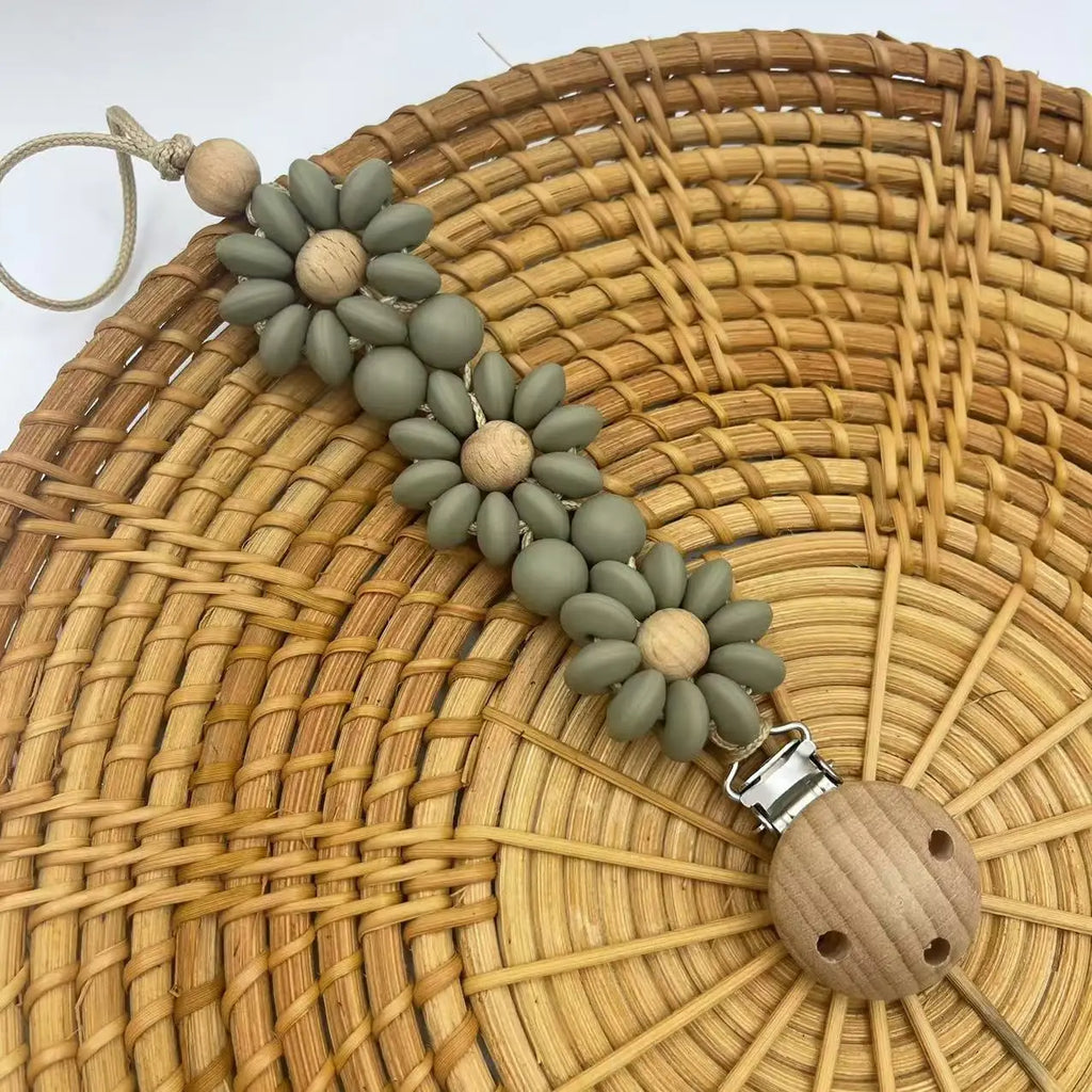 Attache Tétine Petite Fleur Marguerite, un accessoire stylé et pratique pour garder la tétine de bébé à portée de main.