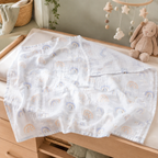 Couverture d’emmaillotage bébé en mousseline sur une table à langer