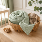 Couverture bébé en mousseline sauge dans un panier en chambre de bébé
