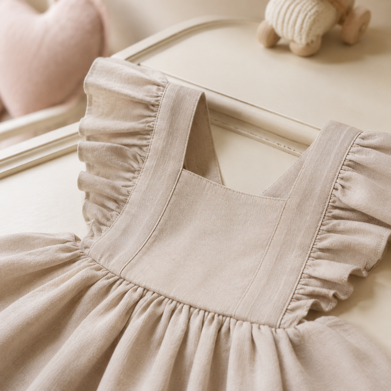 Détail des volants et du tissu de la robe bébé beige