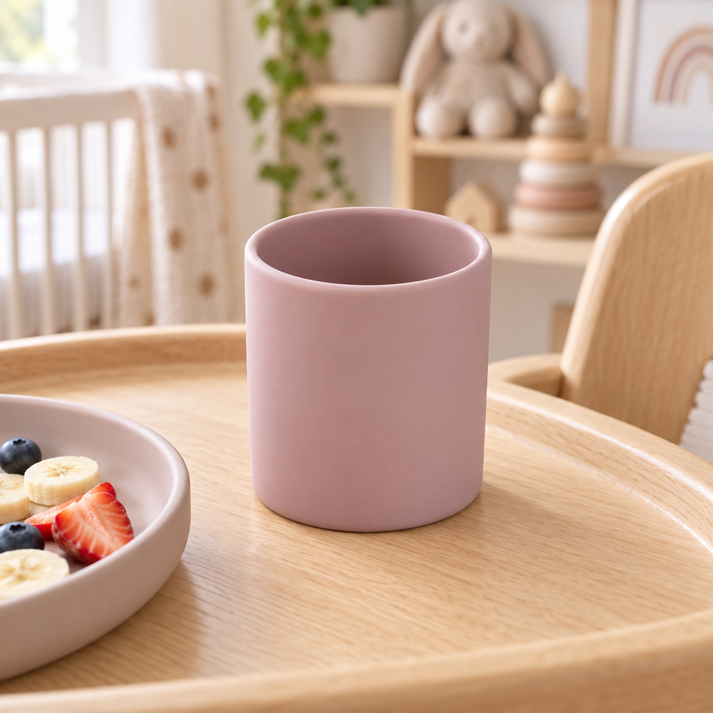 Gobelet bébé en silicone rose poudré sur chaise haute