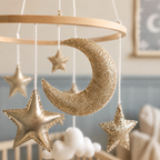 Détail de la lune et des étoiles dorées du mobile bébé