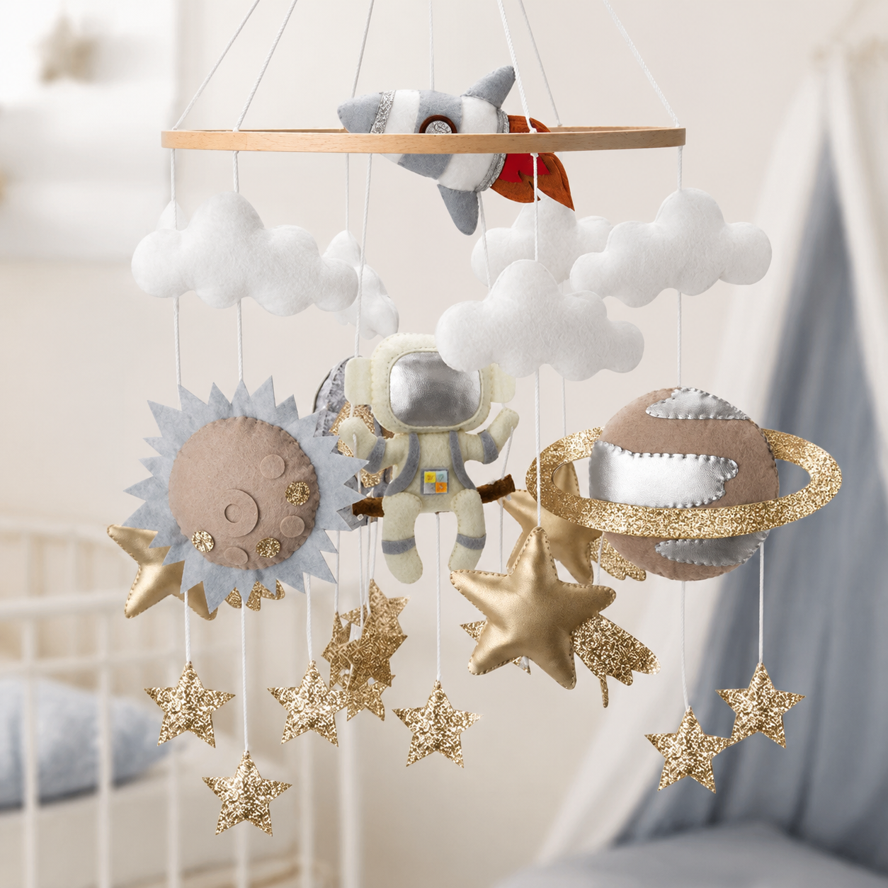 Mobile bébé astronaute et planètes en feutrine dans une chambre de bébé