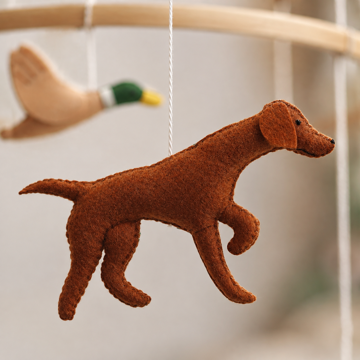 Détail du chien en feutrine marron du mobile bébé