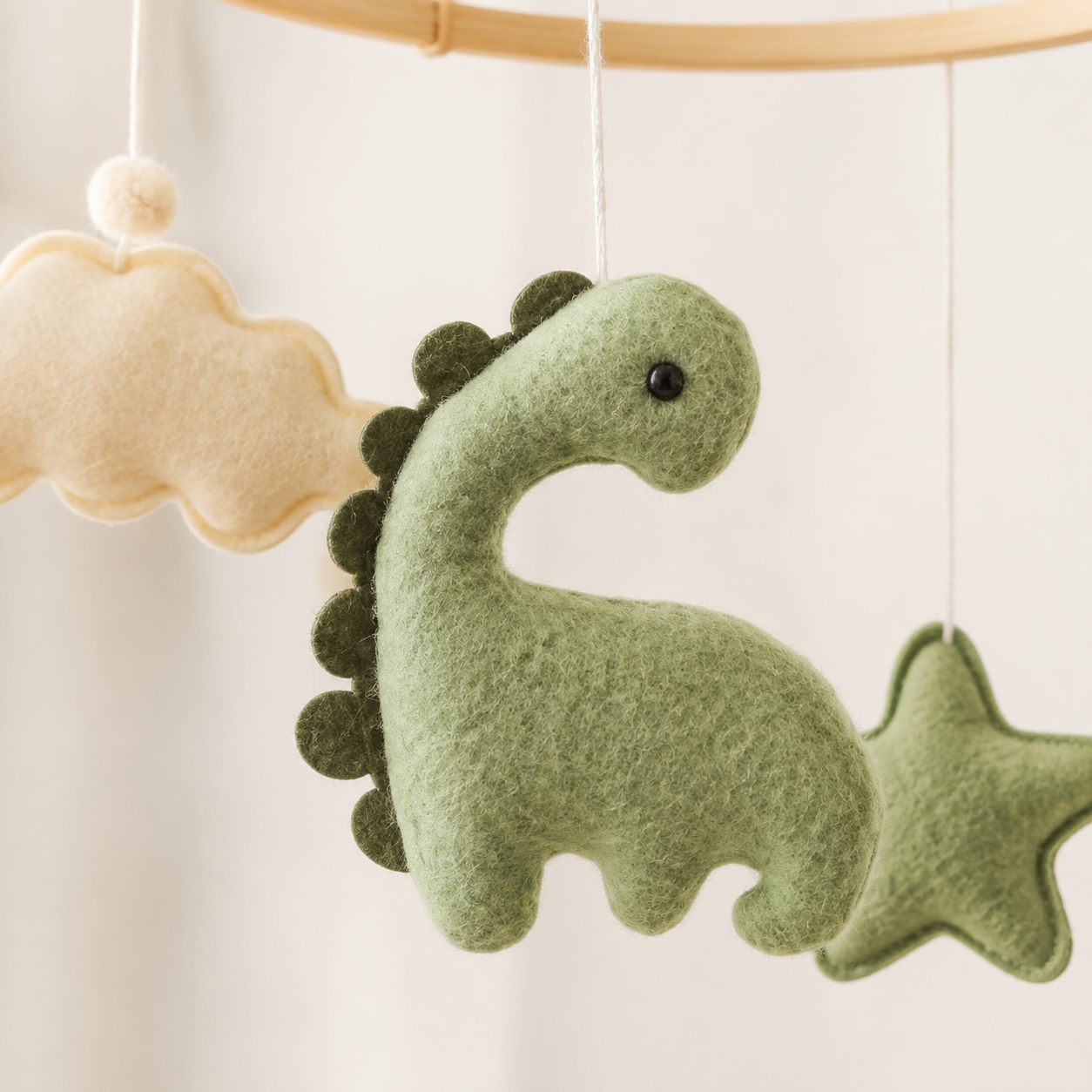 Détail du petit dinosaure vert sauge en feutrine