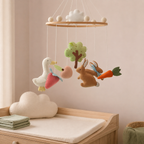 Mobile bébé lapins du jardin près d’une table à langer