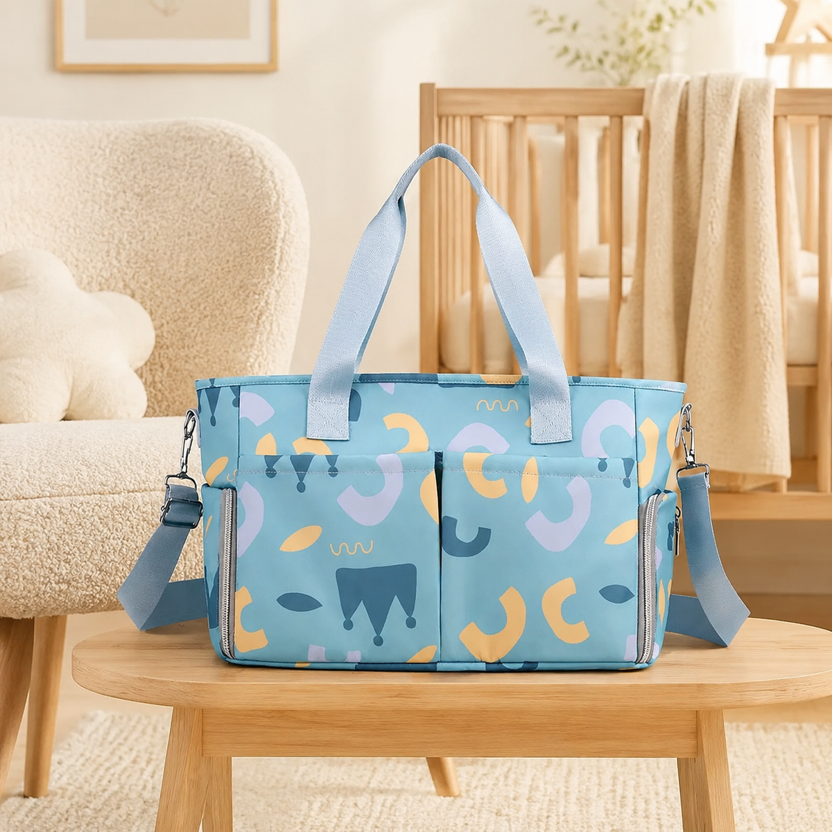 Sac à langer multipoches Bleu graphique mis en scène près d’un berceau